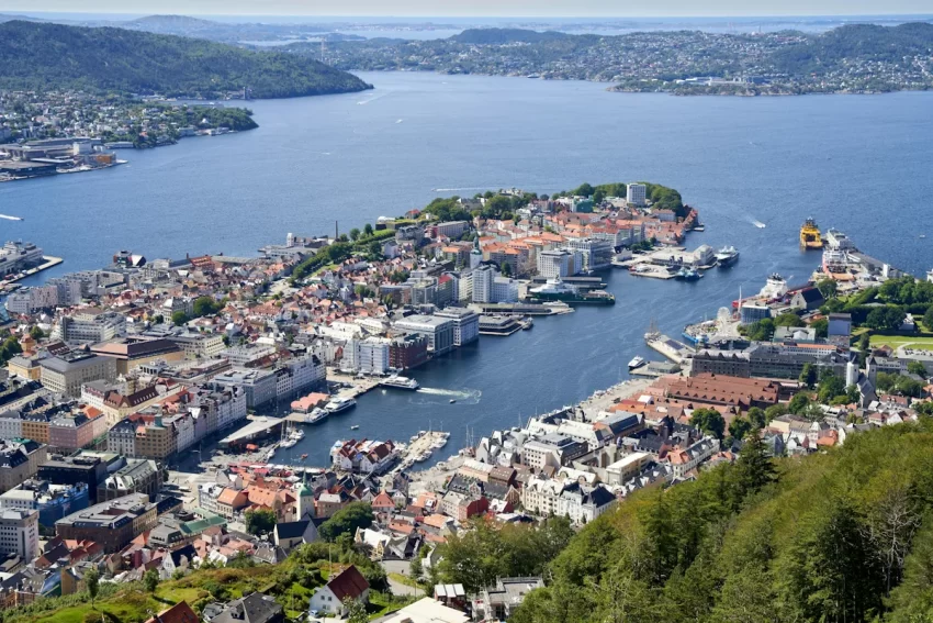 Utsikt över Bergen med stadskärnan, hamnen och omgivande fjäll sedda ovanifrån